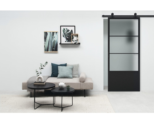 Woonkamer met schuifdeur, bank, salontafel en wanddecoratie