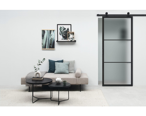 Woonkamer met schuifdeur, bank, salontafels en wanddecoratie voor een stijlvolle ambiance