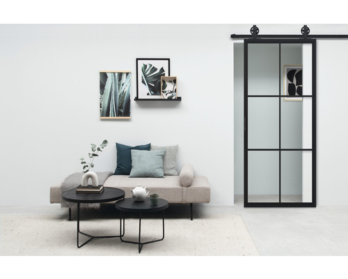 Woonkamer met bank, salontafel, foto''s aan de muur en schuifdeur