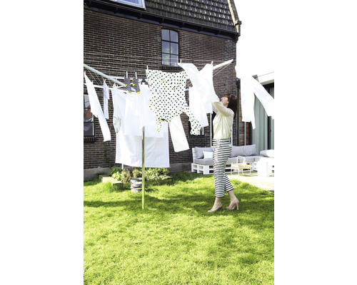 Droogmolen in de tuin met wasgoed en vrouw