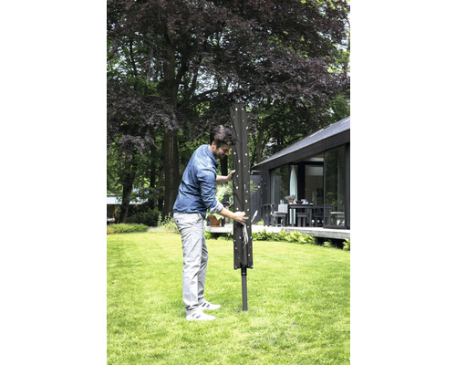 Man bedient wasmolen in de tuin