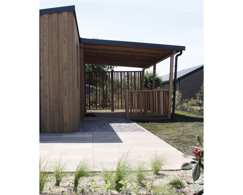Buitenaanzicht van een houten huis met terras en stenen pad