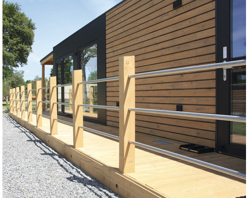 Buitenaanzicht van een huis met houten bekleding en houten terras met leuning