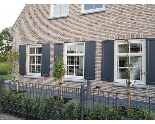 Gevel van een huis met ramen en luiken