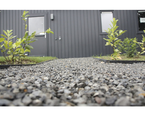 Buitenfoto van een grindpad voor een huis met een voordeur