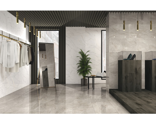 Lichte ruimte met marmeren tegels, kleding, spiegel en schoenen in vitrines