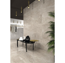 Lichte ruimte met tegels in marmerlook op de vloer en wand, kledingrek en tafel met decoratie