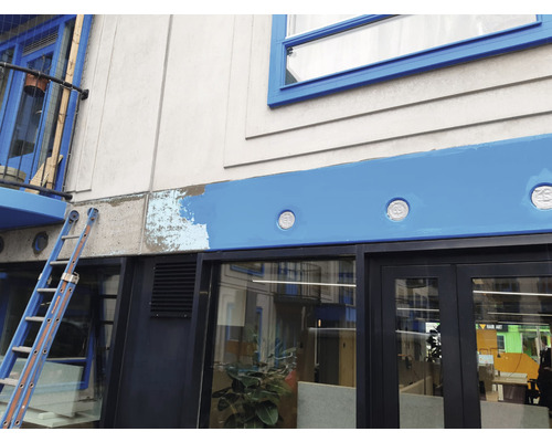 Gevel van een gebouw tijdens renovatiewerkzaamheden met ladder