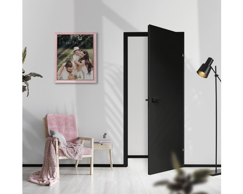 Lichte kamer met deur, fauteuil, vloerlamp en ingelijste familiefoto