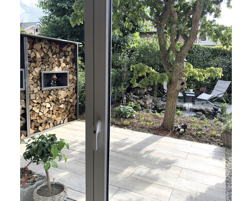 Tuinzicht met houten rek, vijver en tuinmeubelen