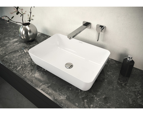 Opzetwastafel op een wastafelblad met kraan en zeepdispenser