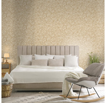 Slaapkamer met bed, kussens, deken, stoel en decoratieve muurafwerking