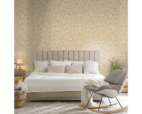 Slaapkamer met bed, kussens, deken, stoel en decoratieve muurafwerking