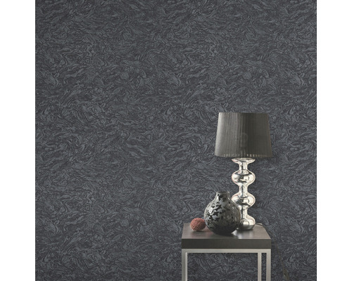 Close-up van een grijs behang met patroon, een tafel, een lamp en een vaas