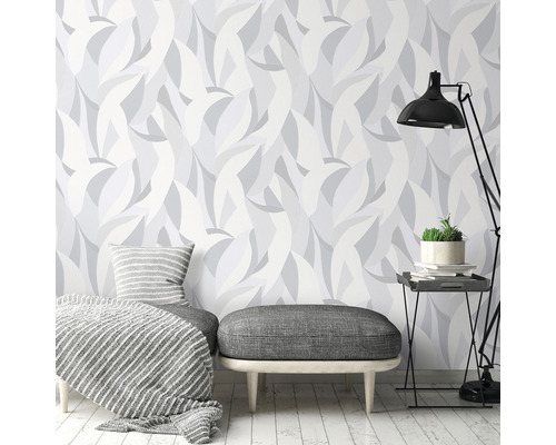 Woonkamer met patroonbehang, zitmeubelen en staande lamp