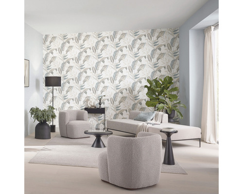 Woonkamer met fauteuils, ligstoel en behang met bladmotief