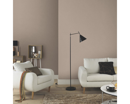 Woonkamer met effen behang, bank, fauteuil en staande lamp voor een uitnodigende sfeer