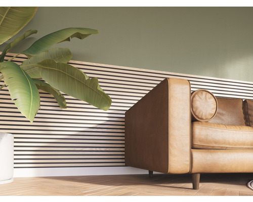 Detailopname van een woonkamer met plant, houten lambrisering en leren bank