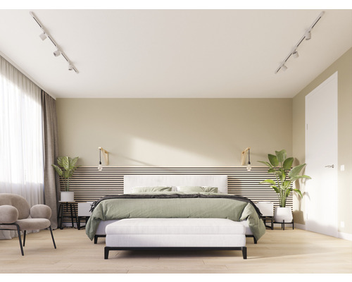 Slaapkamer met tweepersoonsbed, bank, fauteuil en kamerplanten