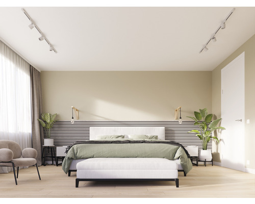 Lichte slaapkamer met bed, bank, fauteuil en kamerplanten