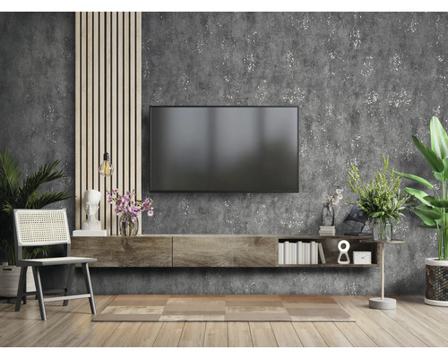 Woonkamer met televisie, dressoir, stoel en decoraties tegen een muur met textuur