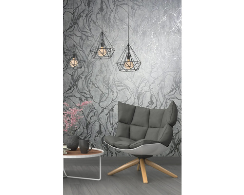 Woonkamer met fauteuil, tafel en geometrische hanglampen voor een bloementjesbehang