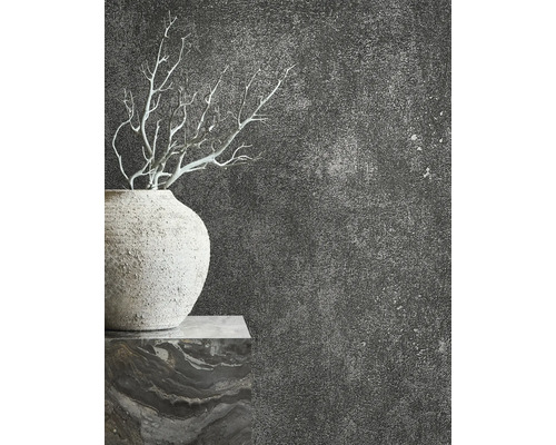 Close-up van een vaas met takken tegen een donkere, gestructureerde muur