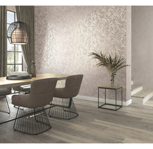Eetkamer met eettafel, stoelen en wandbehang met bladerpatroon.
