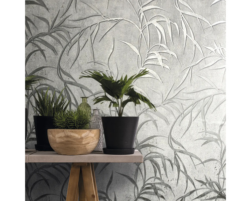 Wanddecoratie met grijs bladerbehang en planten op een tafel