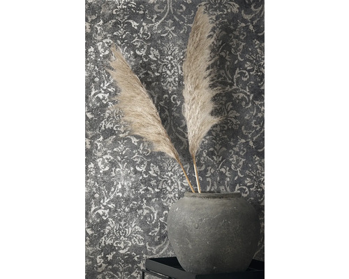 Decoratieve veren in stenen vaas voor een wand met patroonbehang