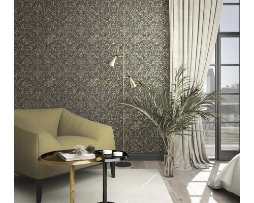 Woonkamer met patroonbehang, fauteuil, staande lamp en kamerplant