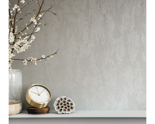 Close-up van een wandbekleding met een abstracte textuur, gecombineerd met een vaas, een klok en een lotusbloem op een plank