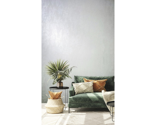 Woonkamer met groene bank, kussens, bijzettafels en decoraties voor een lichte en uitnodigende sfeer.