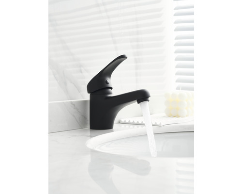 Zwarte kraan met stromend water op een wastafel