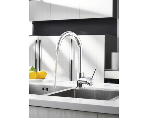 Chromen keukenkraan met stromend water in een gootsteen