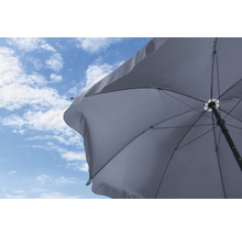 Opengeklapte parasol tegen een blauwe lucht met wolken