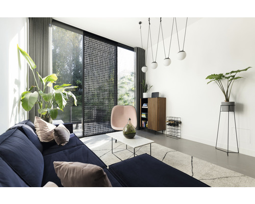 Woonkamer met bank, stoel, kast en planten