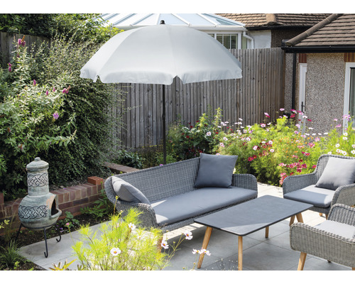 Tuinmeubelset met parasol, bank, stoelen en tafel op een terras.