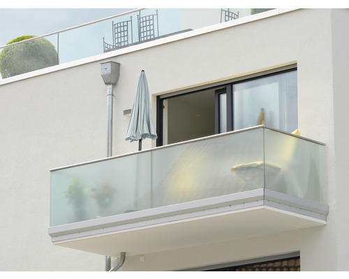 Buitenaanzicht van een balkon met glazen balustrade en parasol