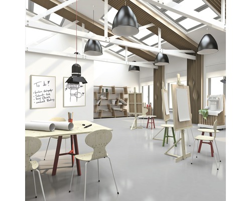 Lichte kunstruimte met tafels, stoelen, schildersezels en planken