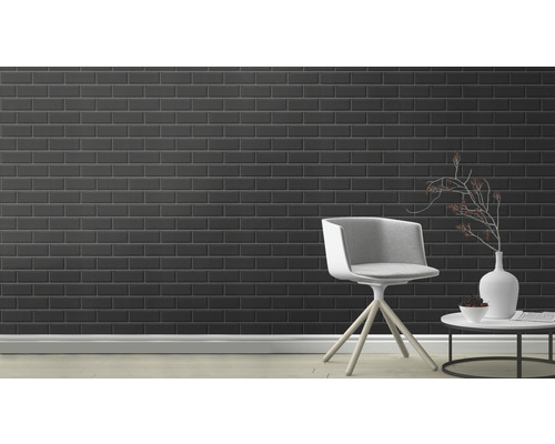 Kamerweergave met zwarte tegels op de wand, een stoel en een tafel