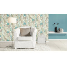 Decoratief behang met bloemmotief, fauteuil en vloerlamp in een interieur.