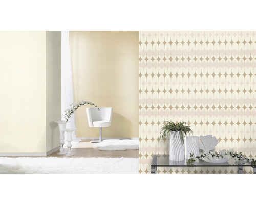 Woonkamer met patroonbehang, fauteuil, tapijt en decoratie