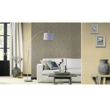 Woonkamer met patroonbehang, bank, staande lamp en decoratieve elementen voor een gezellige sfeer.