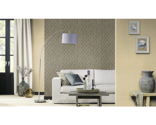 Woonkamer met patroonbehang, bank, staande lamp en decoratieve elementen voor een gezellige sfeer.