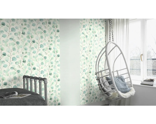 Woonkamer met behang met eucalyptusmotief, bed en hangstoel