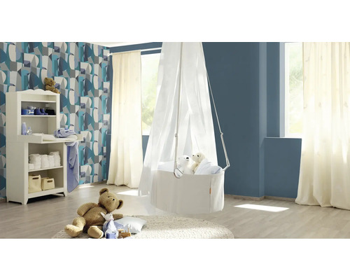 Een kinderkamer met commode, hangmand met hemel en decoratieve artikelen.