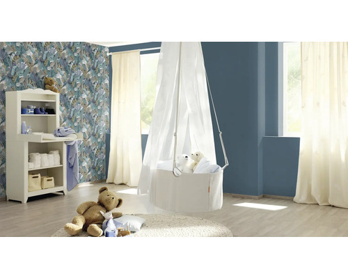 Een lichte kinderkamer met commode, hangmand en een teddybeer op een kleed