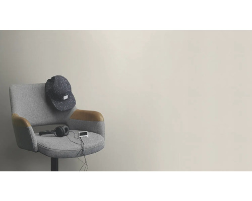Een grijze stoel met een pet, hoofdtelefoon en een apparaat erop.