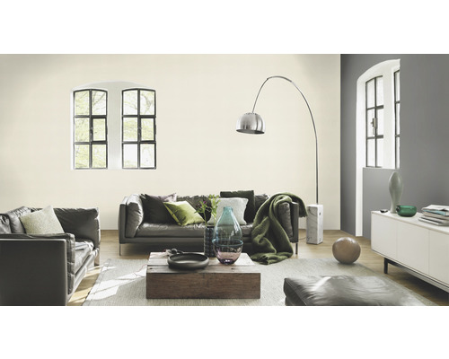 Woonkamer met bank, salontafel, vloerlamp en licht geschilderde muur